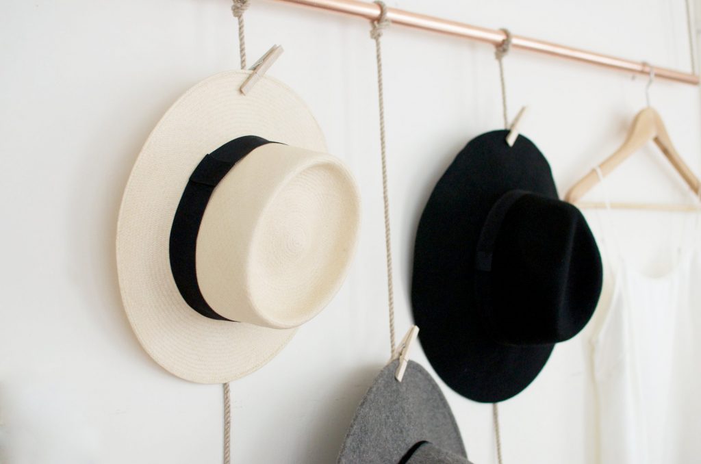 Three hats hanging by clothespins