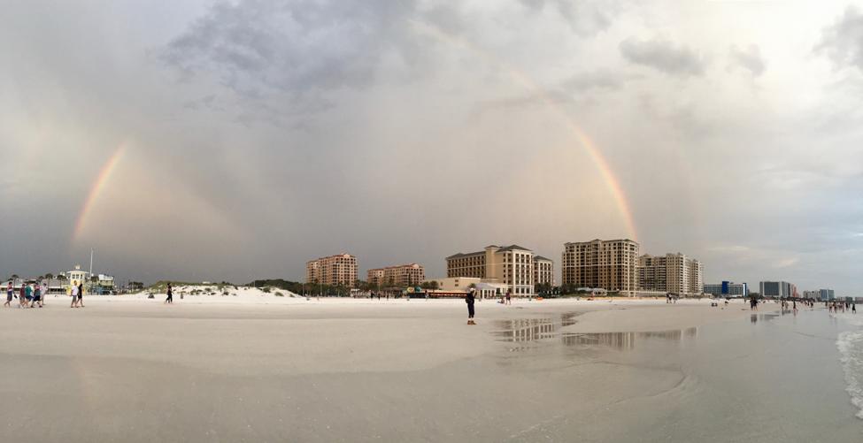 Rainbow over buildings and a beach