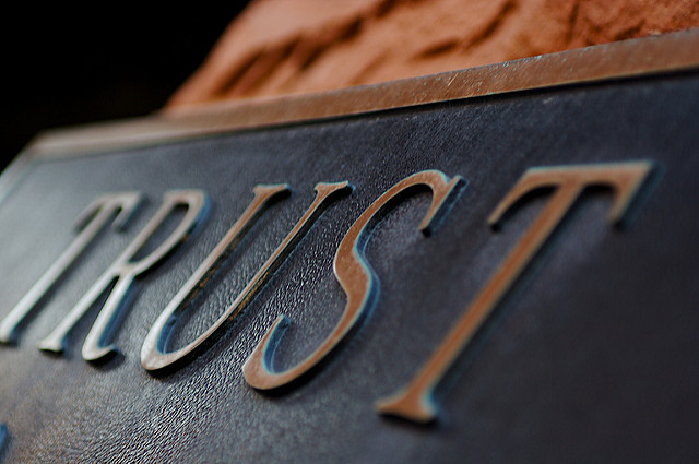 Closeup of a metal plaque reading "Trust"