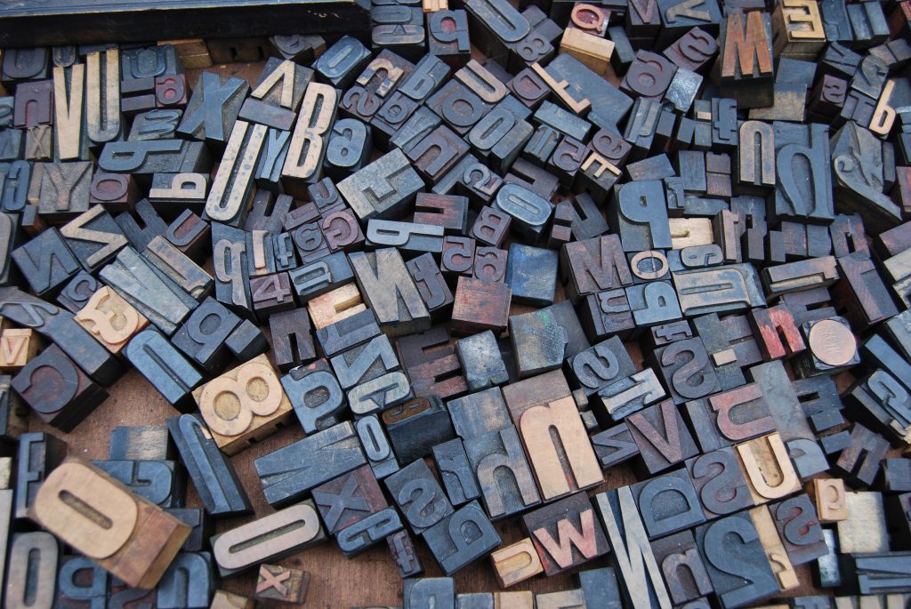 A photo of typographic blocks. Each individual letter varies in size and typeface. 
